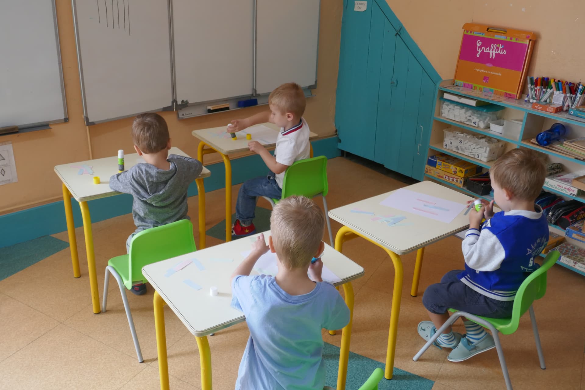 Des élèves travaillant à leur bureau dans une classe colorée